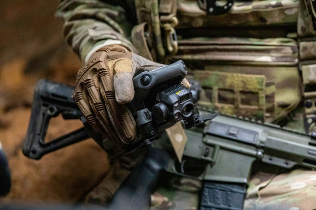 Крупний план зброї з оптичним прицілом у руках бійця бригади «Любарт» Корпусу Азов